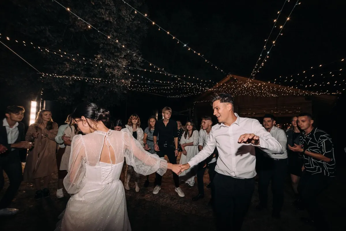 Novios bailando bajo luces en la noche
