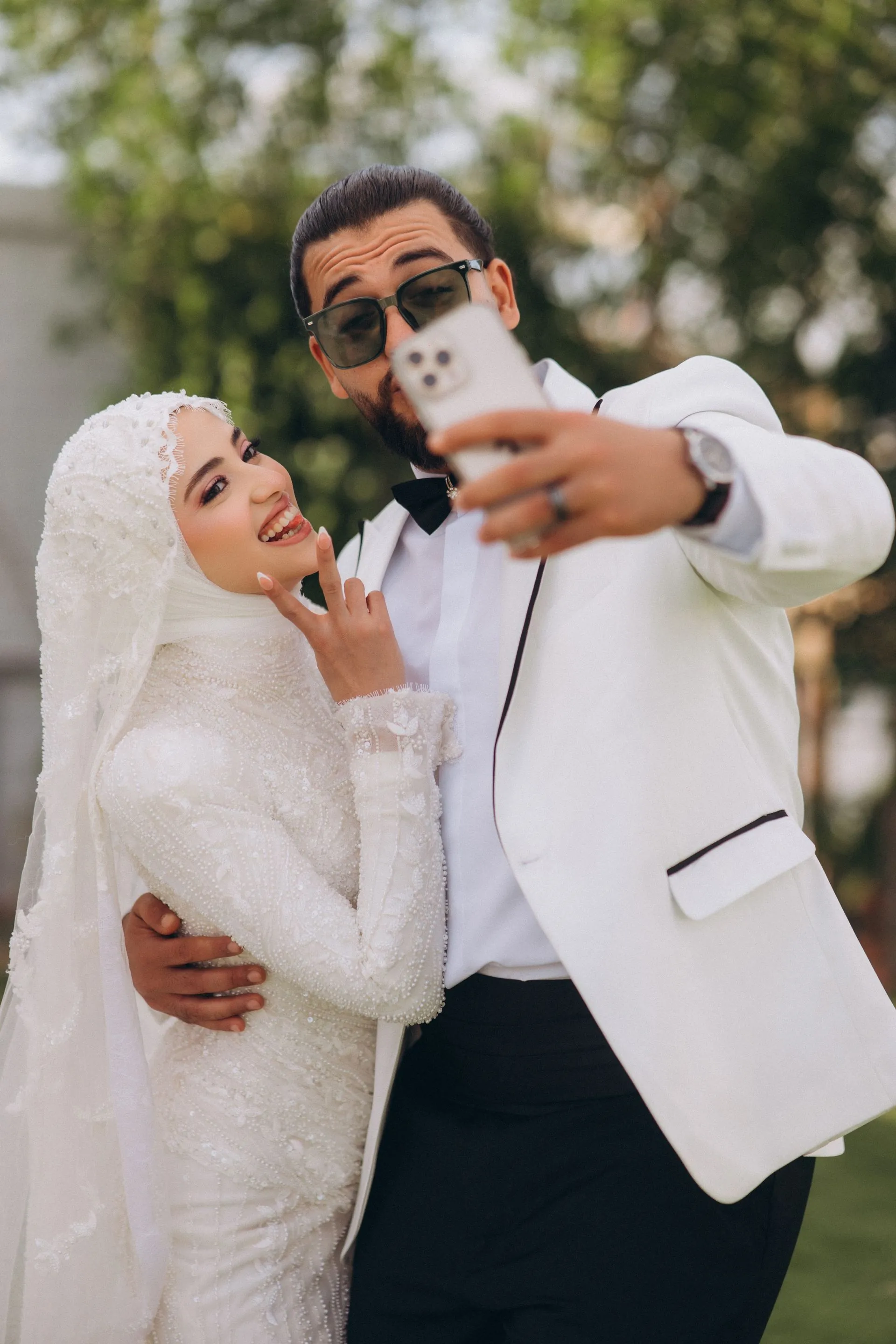 Novios felices tomándose una selfie con el celular el día de su boda