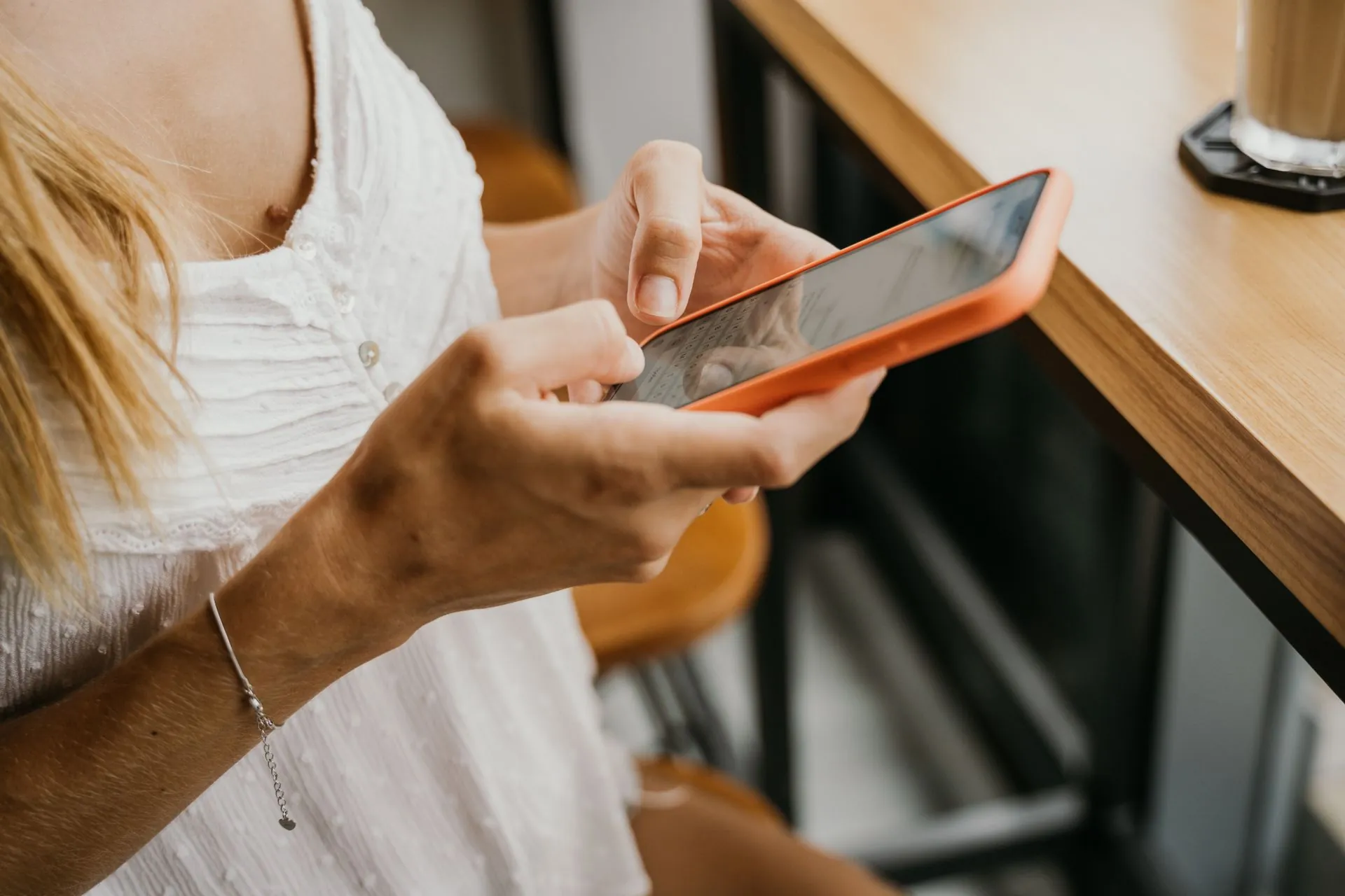 Customer texting a business from her phone at a cafe